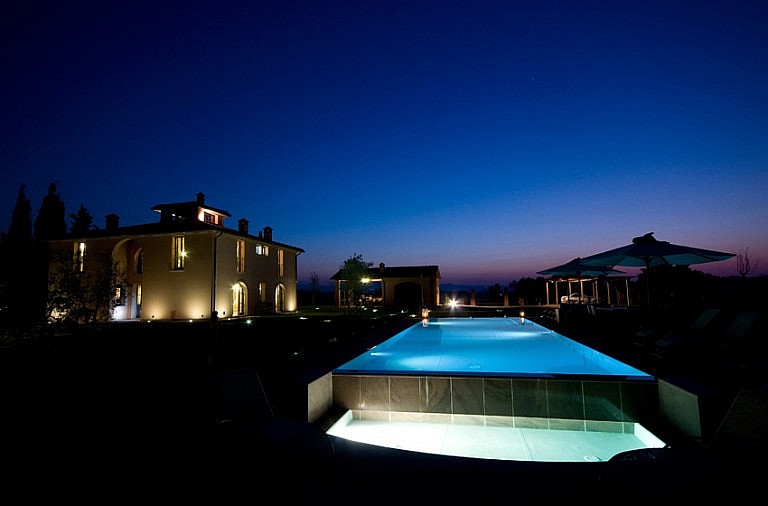 Tuscan cottage at night with infinity pool